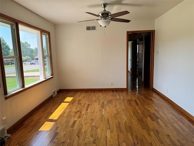 Unfurnished room with ceiling fan and hardwood / wood-style flooring