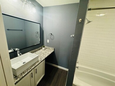 Full bath with wood finished floors, vanity, wash
