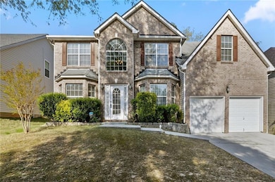 Traditional home featuring driveway, a garage, and brick siding