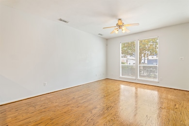 Large windows and hardwood floors create a wonderf