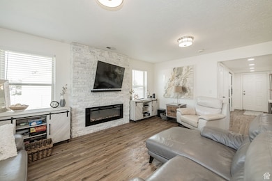 Living area with wood finished floors, a fireplace, and a textured ceiling