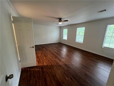 Unfurnished room featuring crown molding, dark woo