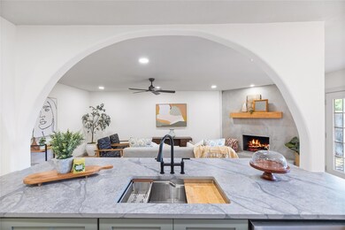 Kitchen with sink, light stone countertops, a larg