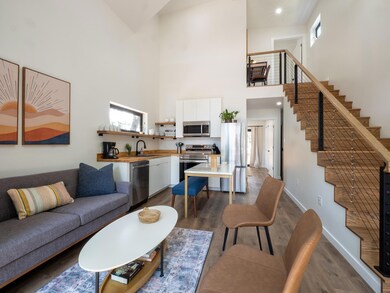 Living area featuring a towering ceiling, dark wo