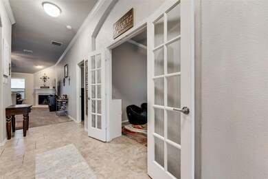 Hall with ornamental molding, French doors, and light tile flooring