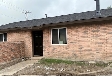 View of exterior entry featuring brick siding and