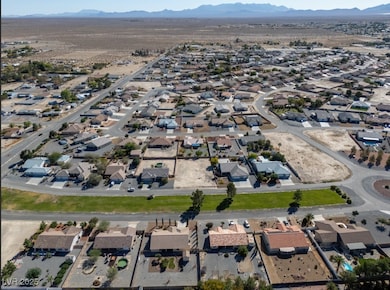 Aerial view of property's location with a mountainous background and nearby suburban area