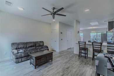 Living room with wood finished floors, ceiling fa
