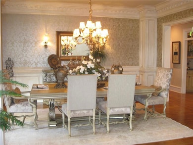 Dining room featuring wallpapered walls, a chandel