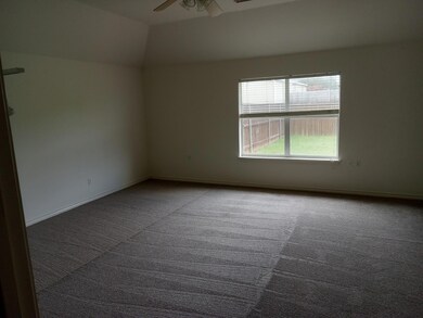 Empty room featuring carpet, ceiling fan, and lofted ceiling