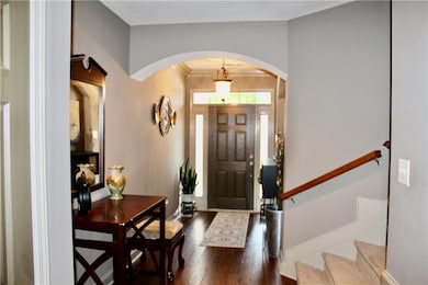 Entryway with dark wood-type flooring and arched walkways