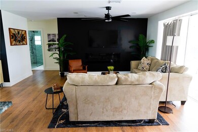 Living room with baseboards, ceiling fan, visible 