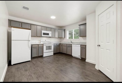 This well-lit kitchen features granite countertops