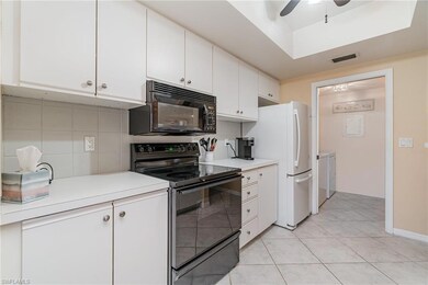 Kitchen featuring white cabinets, light tile patterned floors, and tasteful backsplash