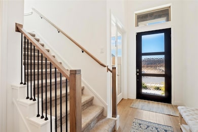Foyer featuring stairs and light wood-style floors