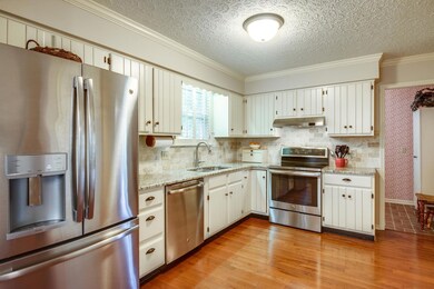 Large eat in kitchen with granite, hardwood floors & stainless steel appliances. 