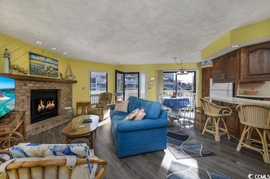 Living room with a brick fireplace, a textured cei
