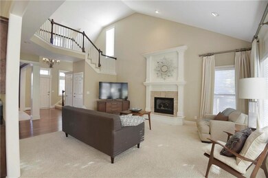 Living room with raised fireplace, soaring ceiling