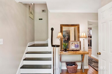Stairs with crown molding and wood finished floors