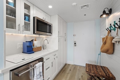 This is a modern kitchen with white shaker style c