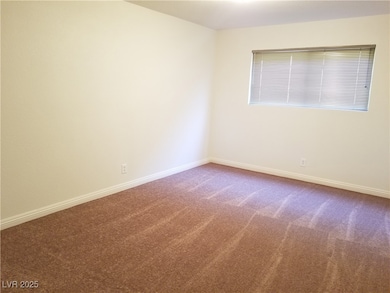 Carpeted empty room with baseboards