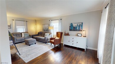 Living room featuring dark hardwood / wood-style floors, crown molding, and a healthy amount of sunlight
