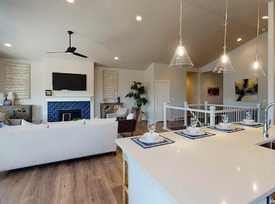 Living area featuring dark wood-type flooring, a tile fireplace, recessed lighting, and a ceiling fan