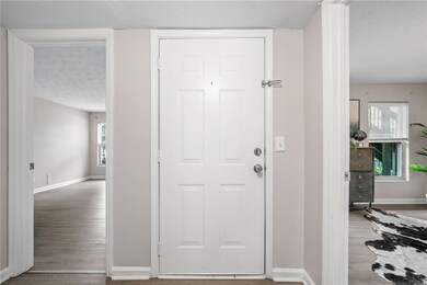 Entryway featuring wood finished floors, baseboards, and a textured ceiling