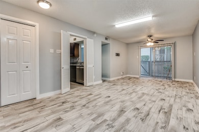 Spare room featuring a textured ceiling, light wood-type flooring, and a ceiling fan