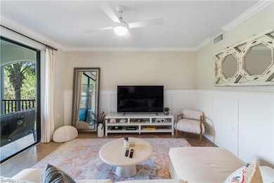 Living room with crown molding and ceiling fan