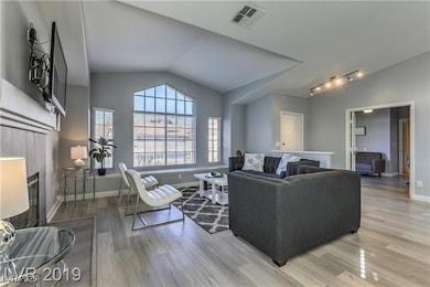 Living area featuring lofted ceiling, light wood-s