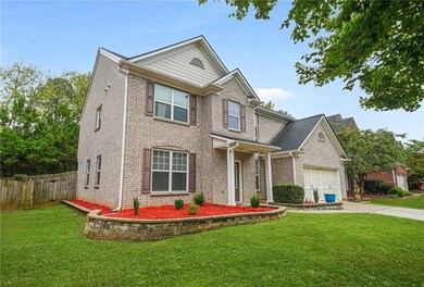 Traditional-style home with driveway, a garage, and brick siding