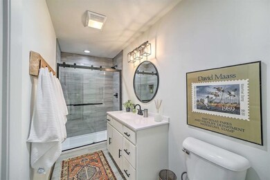 Bathroom featuring a shower stall, vanity, and toi