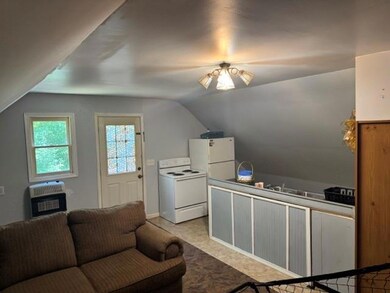 Kitchen with white appliances, heating unit, and vaulted ceiling