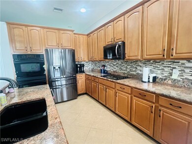 Kitchen featuring backsplash, black appliances, li