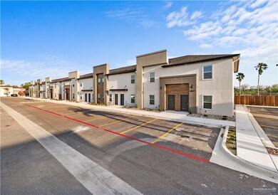 View of building exterior with fence, a residential view, and uncovered parking
