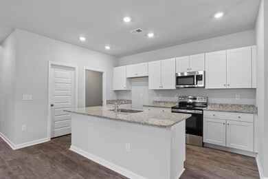Kitchen with white cabinets, sink, an island with 
