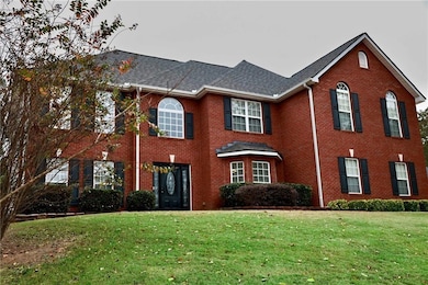 Colonial-style house featuring a front yard and brick siding