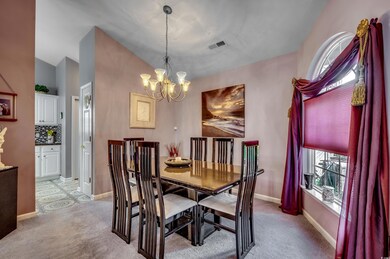 Carpeted dining room with vaulted ceiling and a ch