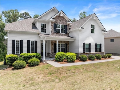 Craftsman-style house with stone siding, a front yard, and covered porch
