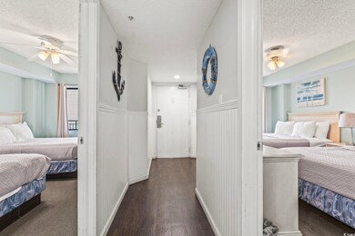 Bedroom featuring ceiling fan, dark wood-type floo