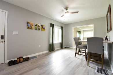 Dining area with ceiling fan and light wood-type flooring