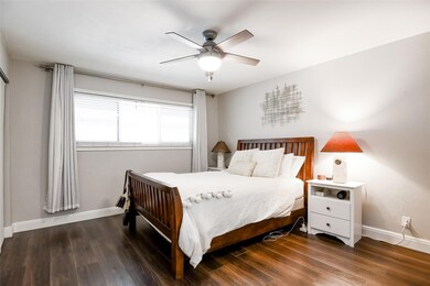 Bedroom with baseboards, ceiling fan, and wood fi