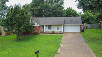 View of front of house featuring concrete driveway, a garage, a porch, and brick siding