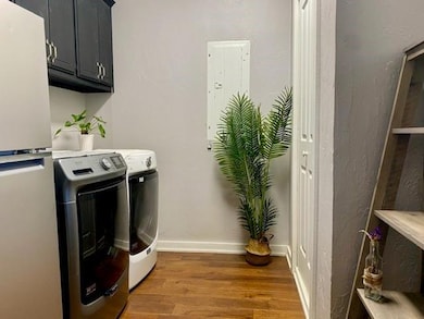 Laundry room with cabinets, dark hardwood / wood-style flooring, and separate washer and dryer