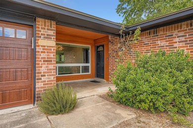 Doorway to property with brick siding and a porch