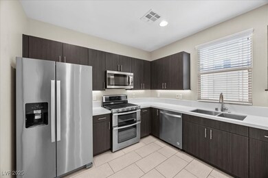 Kitchen with stainless steel appliances, dark brown cabinetry, light tile patterned floors, recessed lighting, and modern cabinets