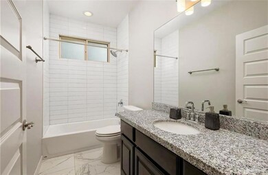 Full bathroom featuring tile flooring, tiled shower / bath combo, toilet, and vanity with extensive cabinet space