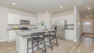 Kitchen featuring an island with sink, white cabin
