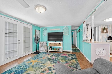 Living room featuring french doors, a textured cei